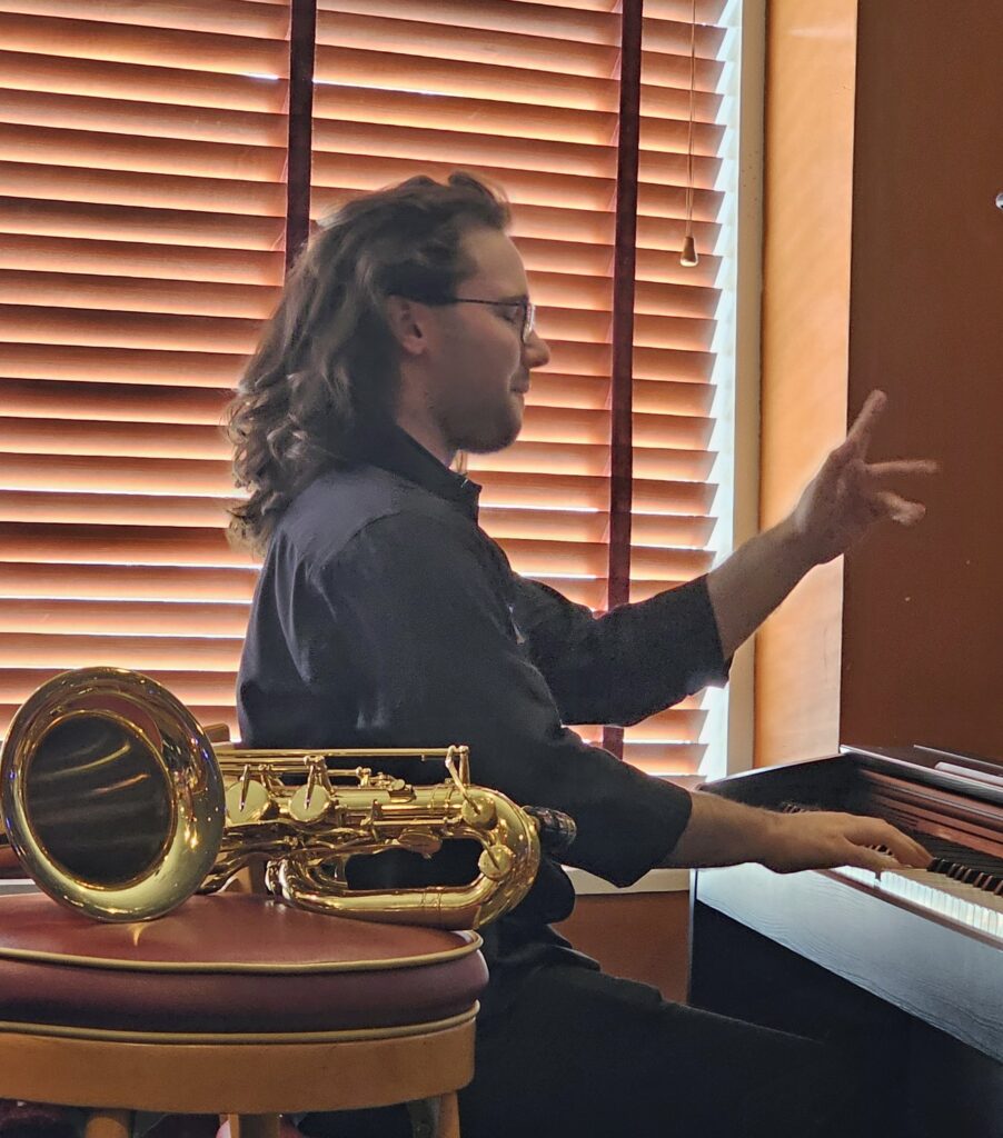 Grant Richter plays the piano during his live performance of his music composition, "Cave of Antiquities"